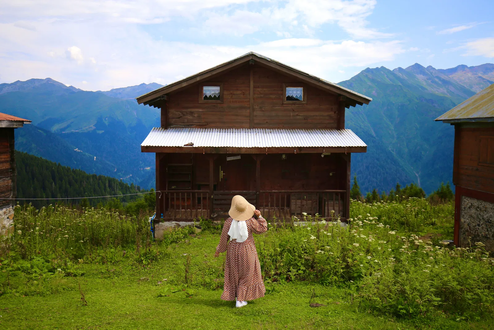 Frau auf dem Weg zu einem Holzhaus in den Bergen